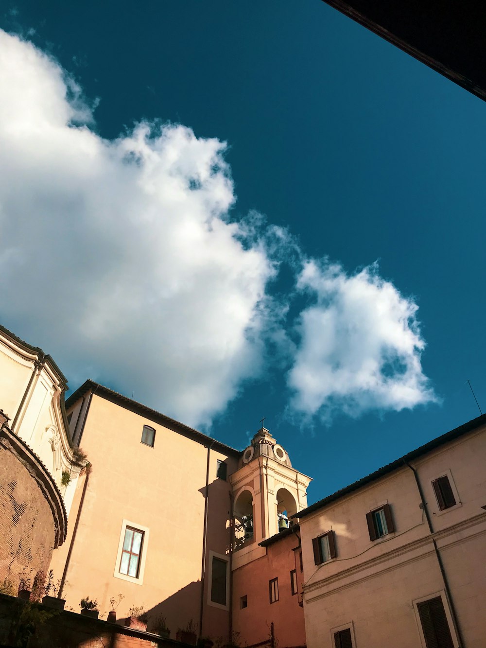 brown concrete building under blue sky and white clouds during daytime