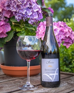 purple flowers beside wine glass