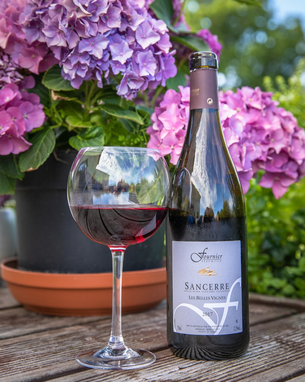 purple flowers beside wine glass