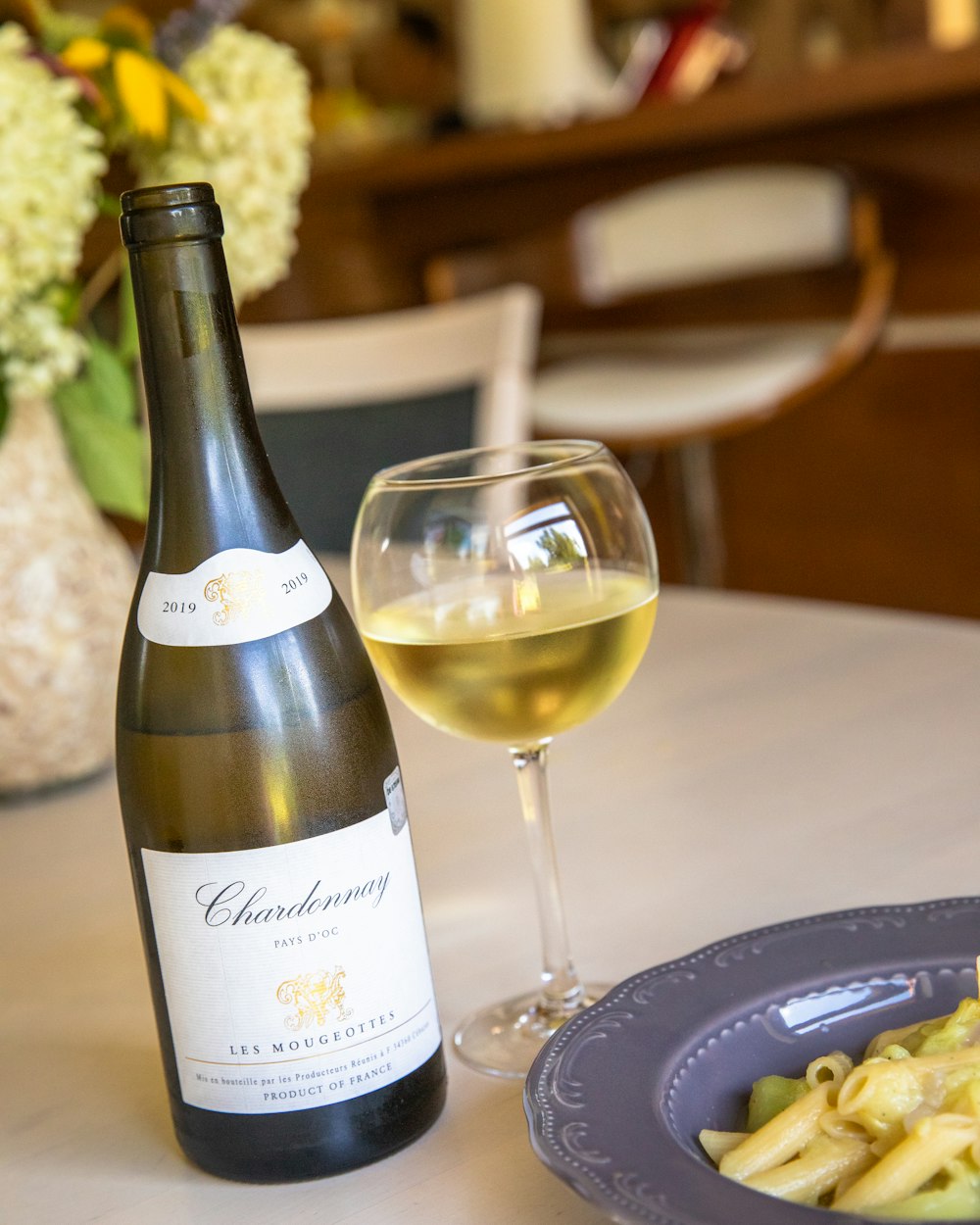 white labeled bottle beside wine glass on table