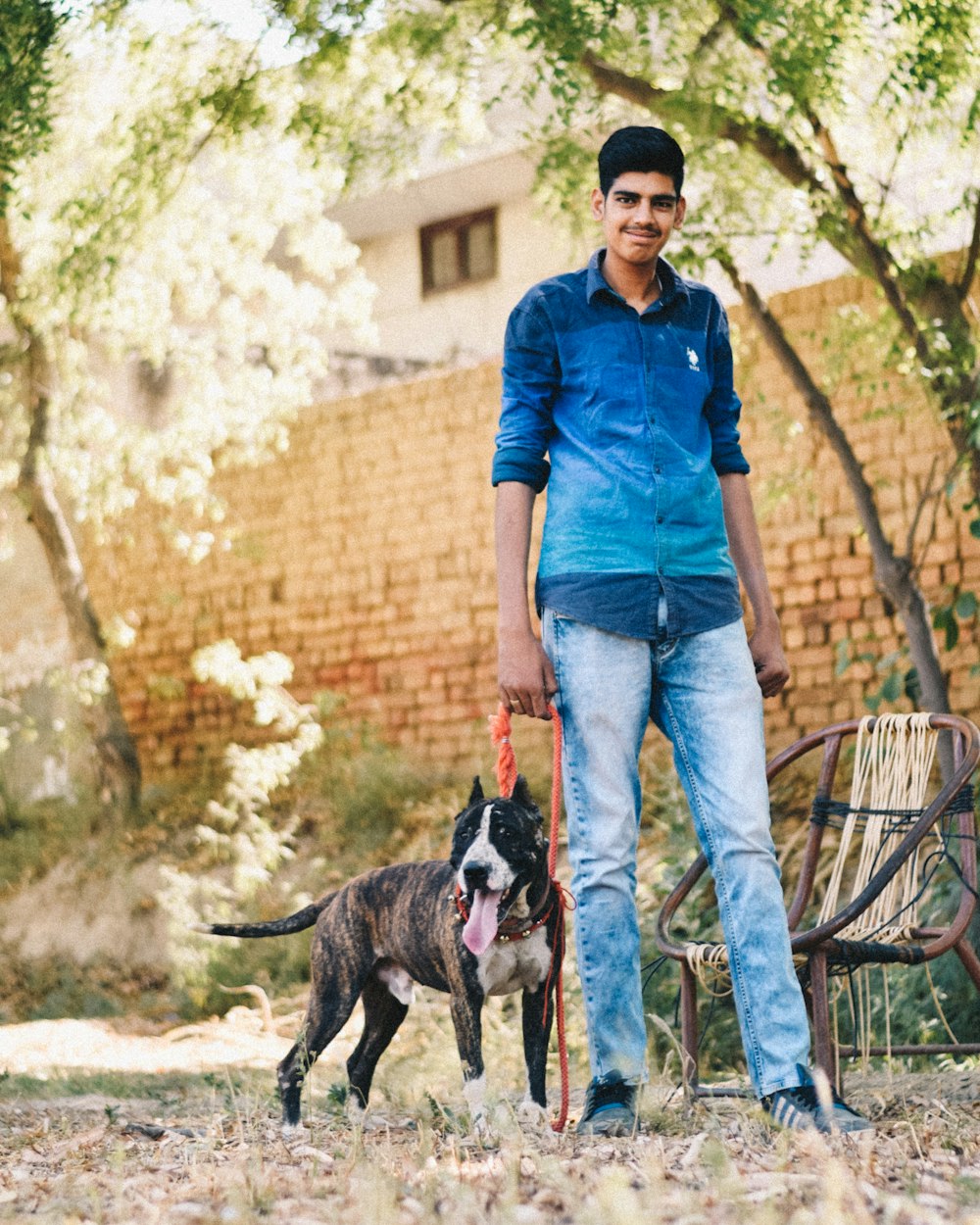 man in blue button up shirt and blue denim jeans standing beside black and white short