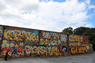 A colorful street art piece with its left corner boldly overlapping the edge of a brick wall.