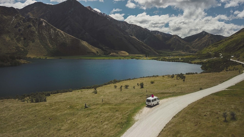 white car on road near lake during daytime