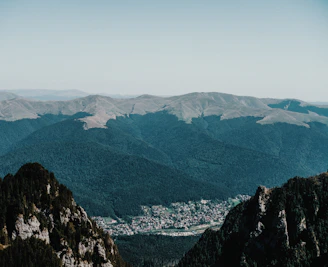 A scenic view of lush green mountains with a small indigenous village nestled in the valley.