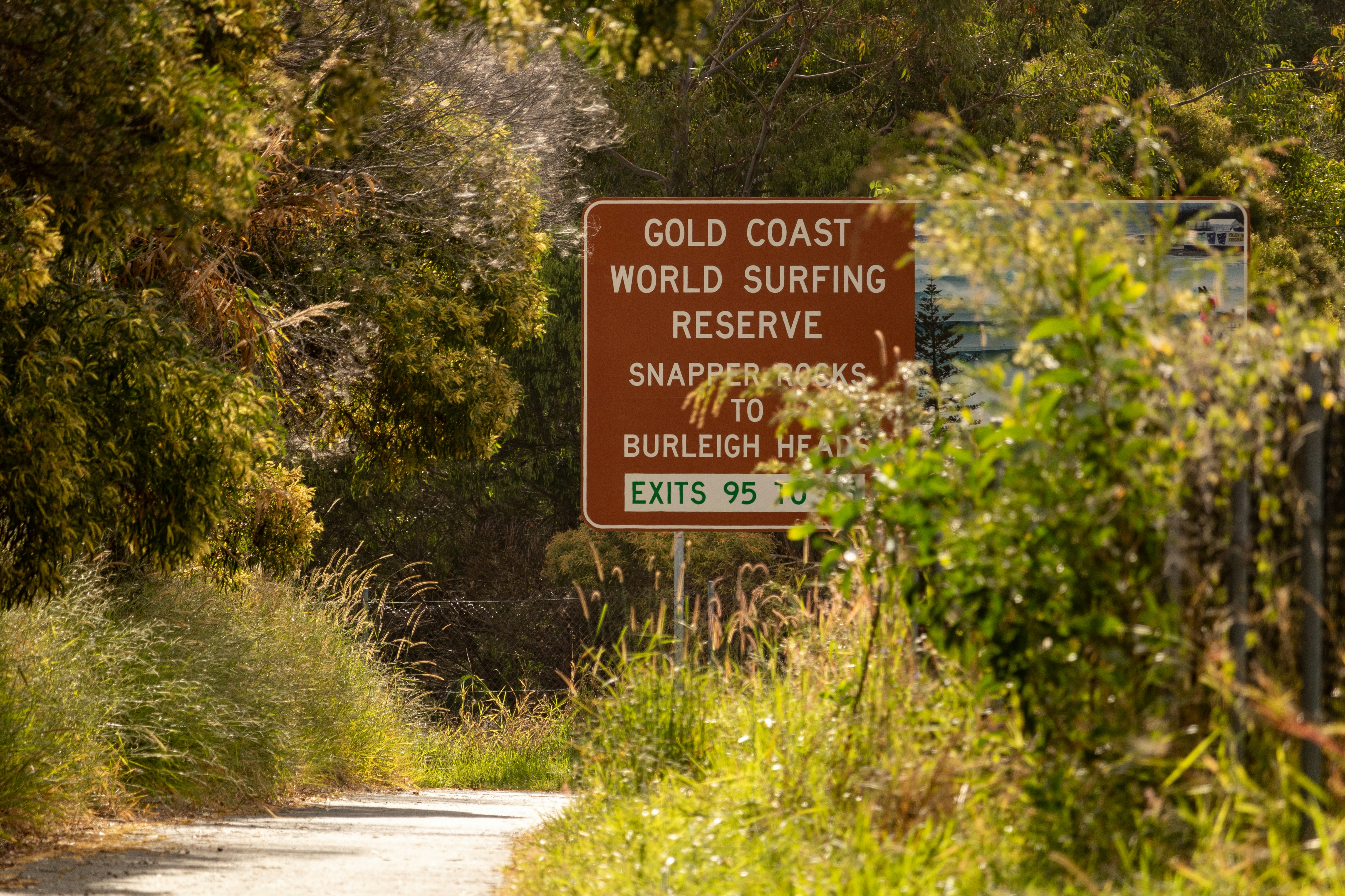 red and white road sign near green plants and trees during daytime