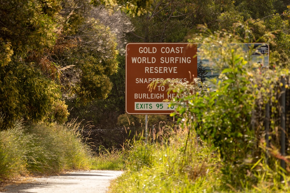 red and white road sign near green plants and trees during daytime