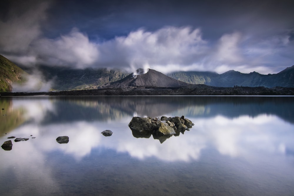 lake near mountain under blue sky during daytime