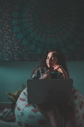A student happily downloading their admit card on a laptop in a cozy study space.