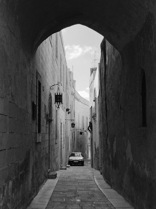 grayscale photo of car parked on side of road in Mdina Malta