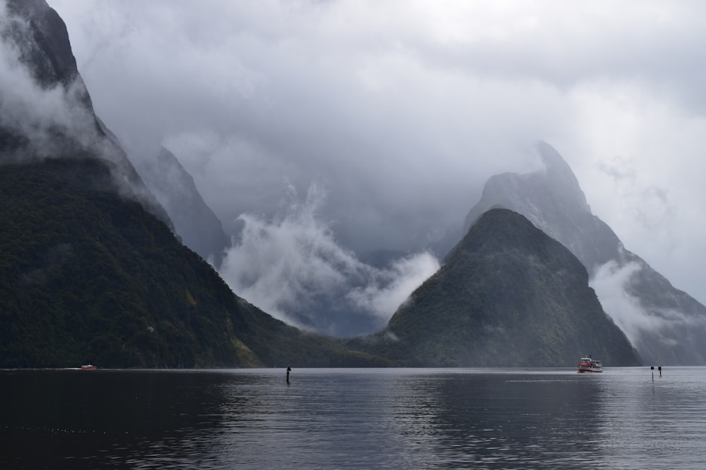 body of water near mountain during daytime