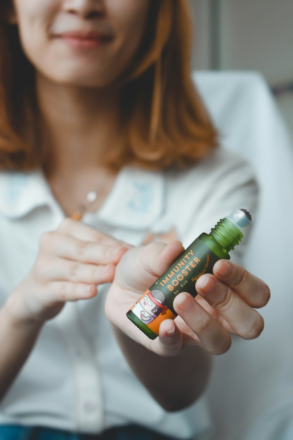 Mujer sosteniendo una botella con etiqueta verde y blanca