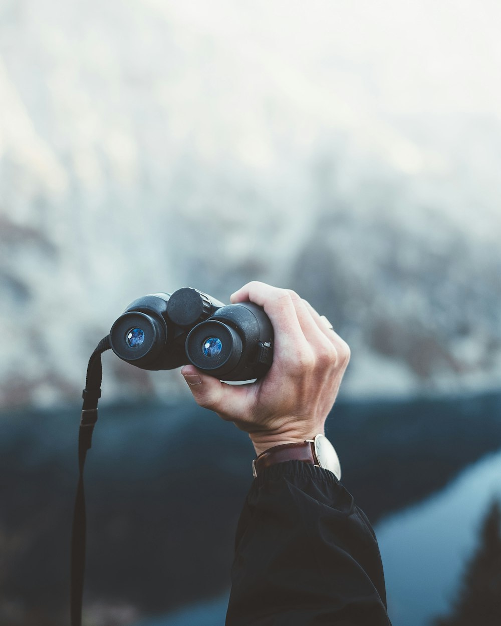 person holding black binoculars during daytime