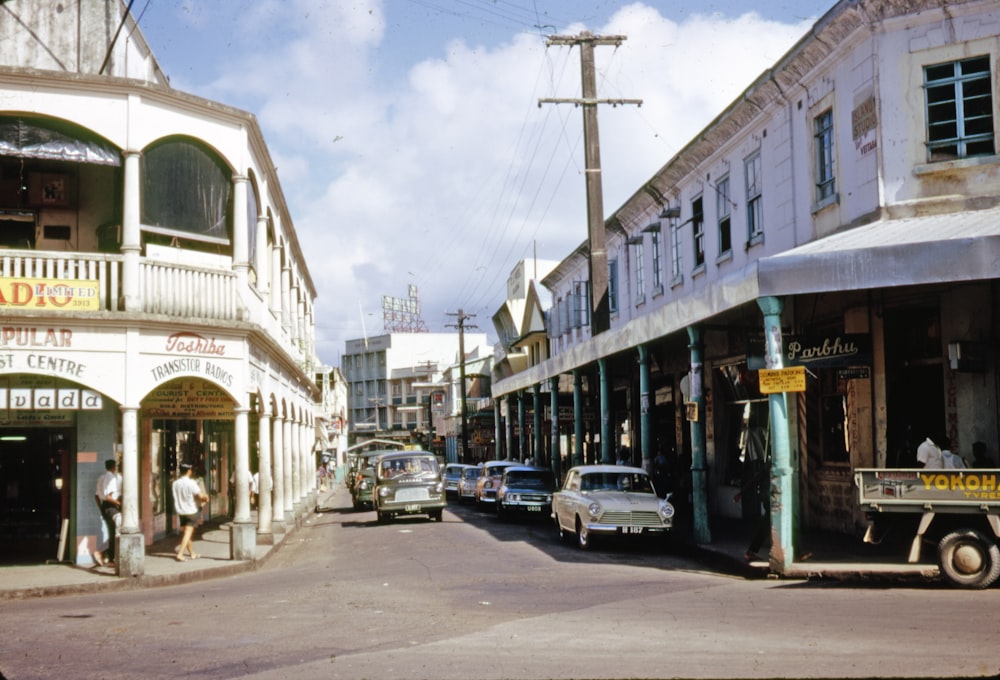 cars parked beside white building during daytime