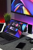 black laptop computer turned on beside silver imac