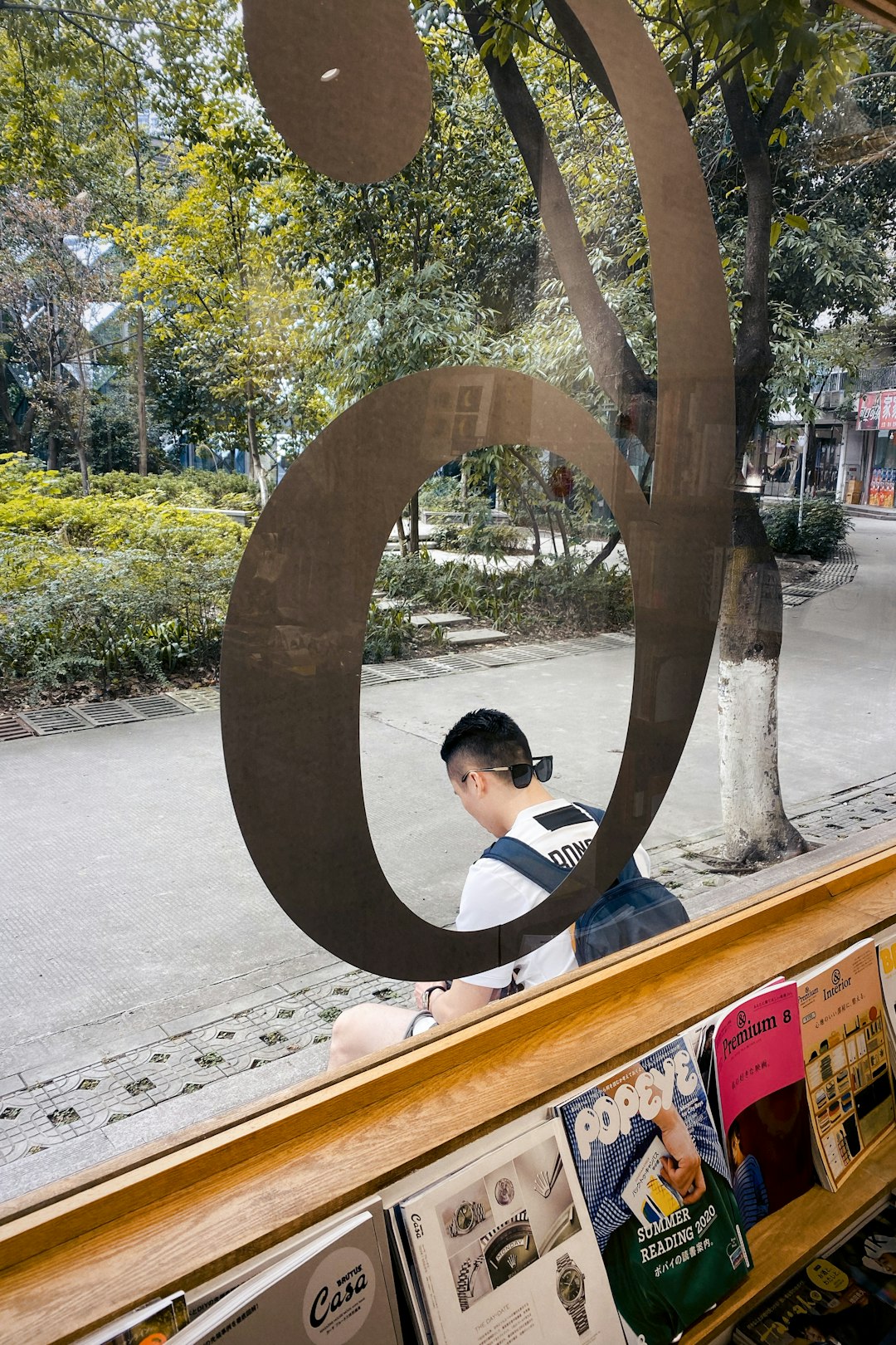 boy in white and black stripe shirt sitting on brown wooden bench during daytime