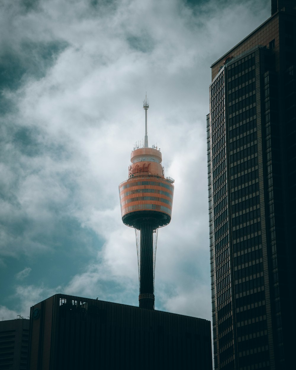 white and red tower under cloudy sky