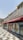 A restaurant storefront with Arabic and English signage reading 'Shake Shack' on the exterior wall. The building features architectural elements like decorative columns and a patterned tile walkway. Large posters on the windows display images of burgers and promotional text in Arabic.