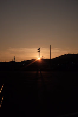 An inspiring sunset behind an industrial plant, symbolizing hope, protection, and continuity.