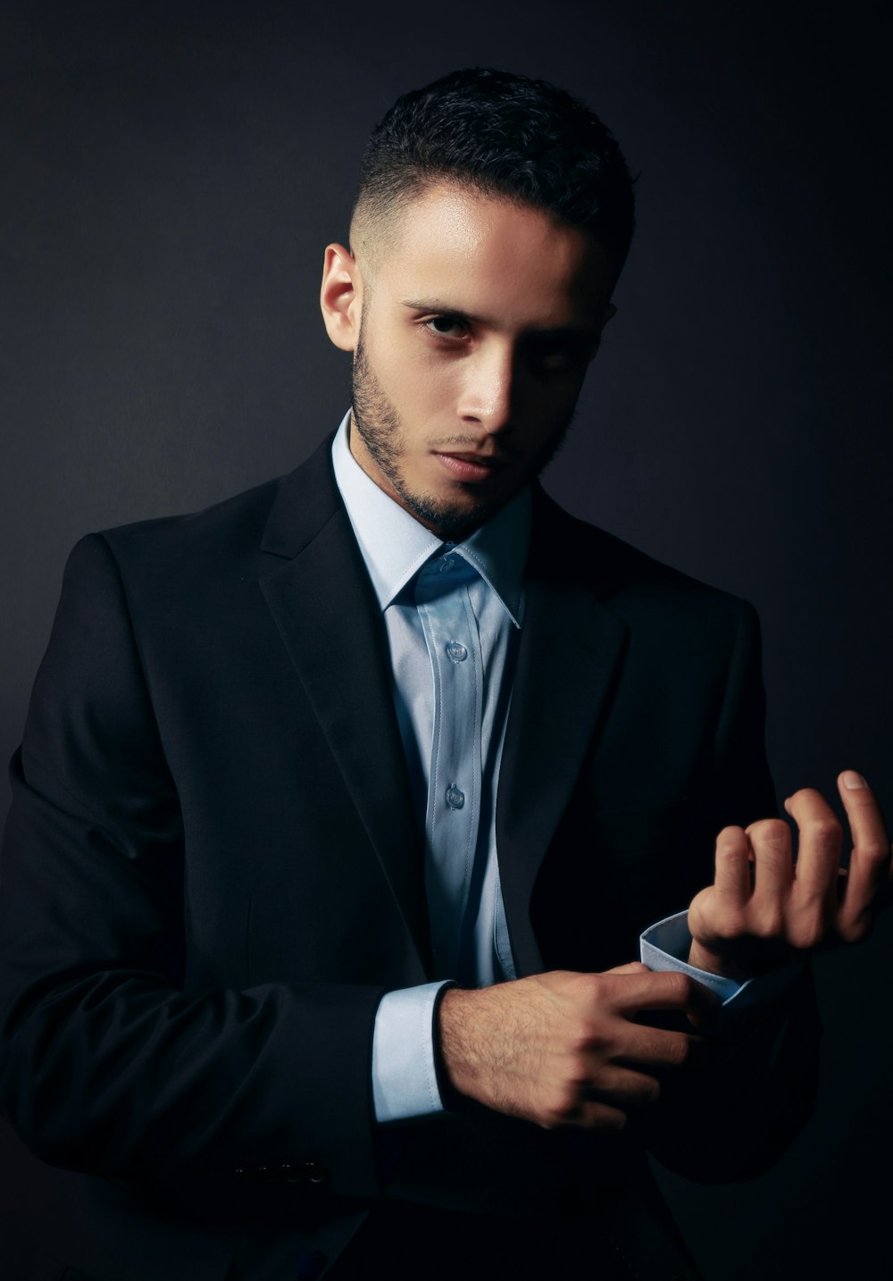 man in black suit jacket holding smartphone