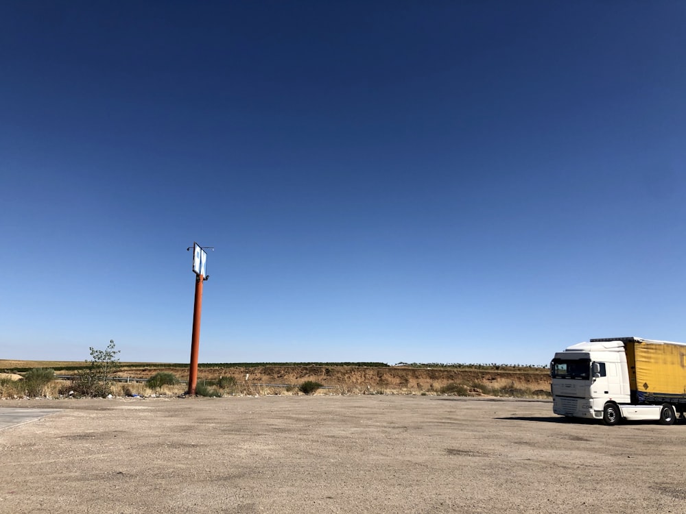 white van on brown field under blue sky during daytime