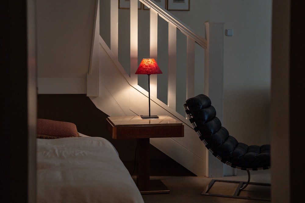 red table lamp turned on on brown wooden table