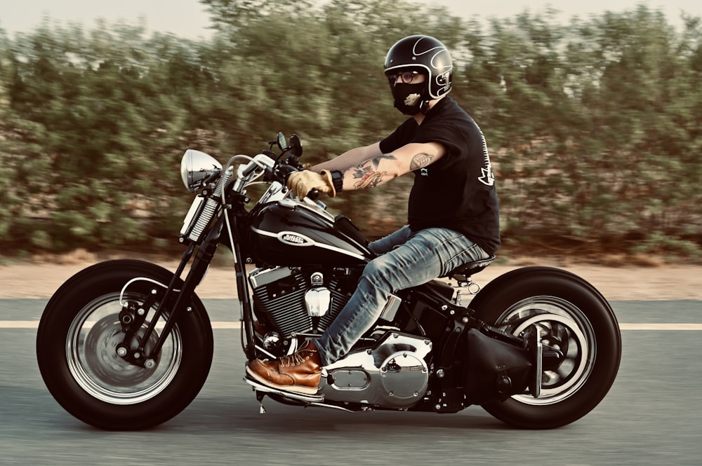 man in black shirt riding on orange and black motorcycle