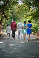 man in red t-shirt and gray pants holding hands with boy in blue t-shirt