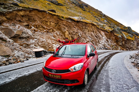 An influencer showcasing a new car model on a scenic mountain road, capturing breathtaking shots.