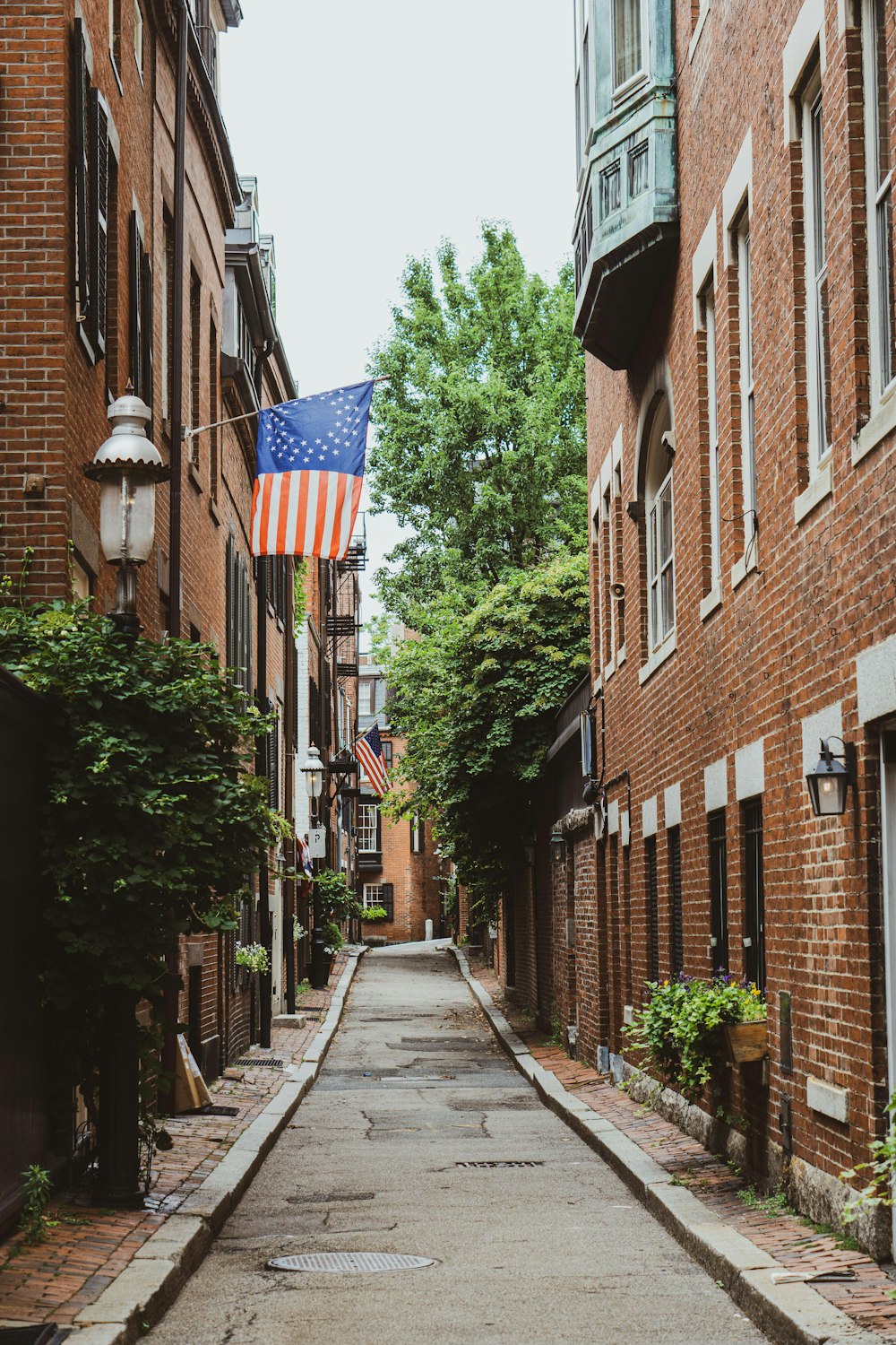 brown brick building with flags on the side of the road