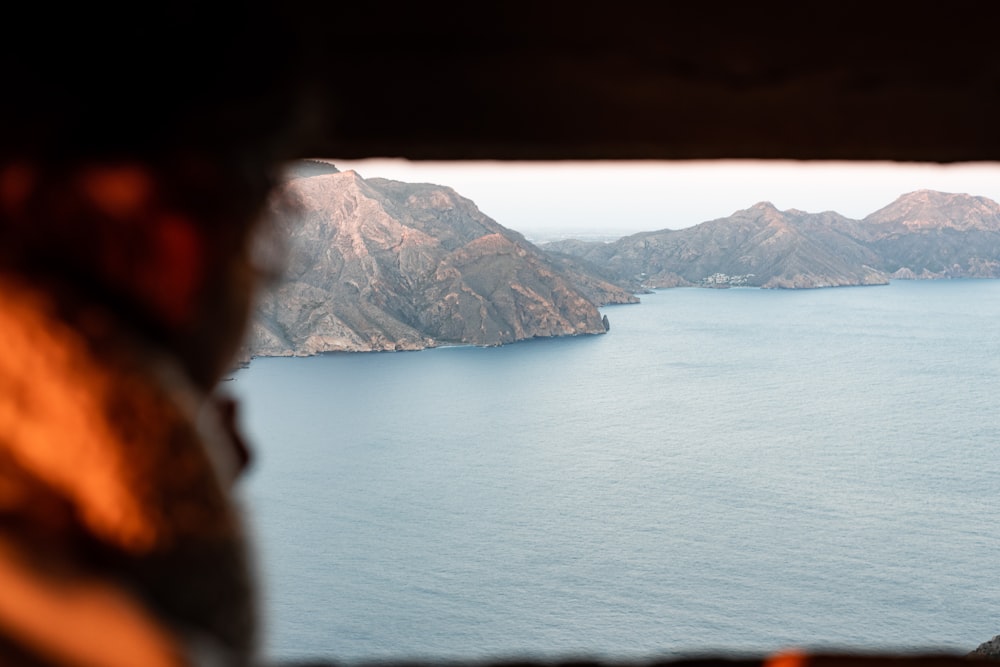 body of water near mountain during daytime