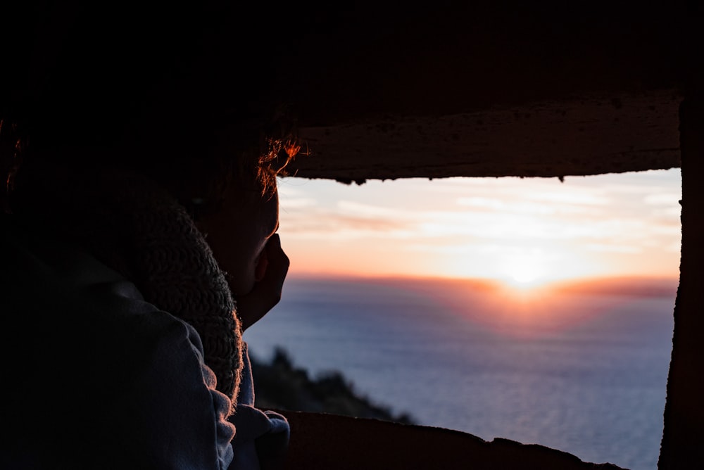 man in black jacket looking at sunset