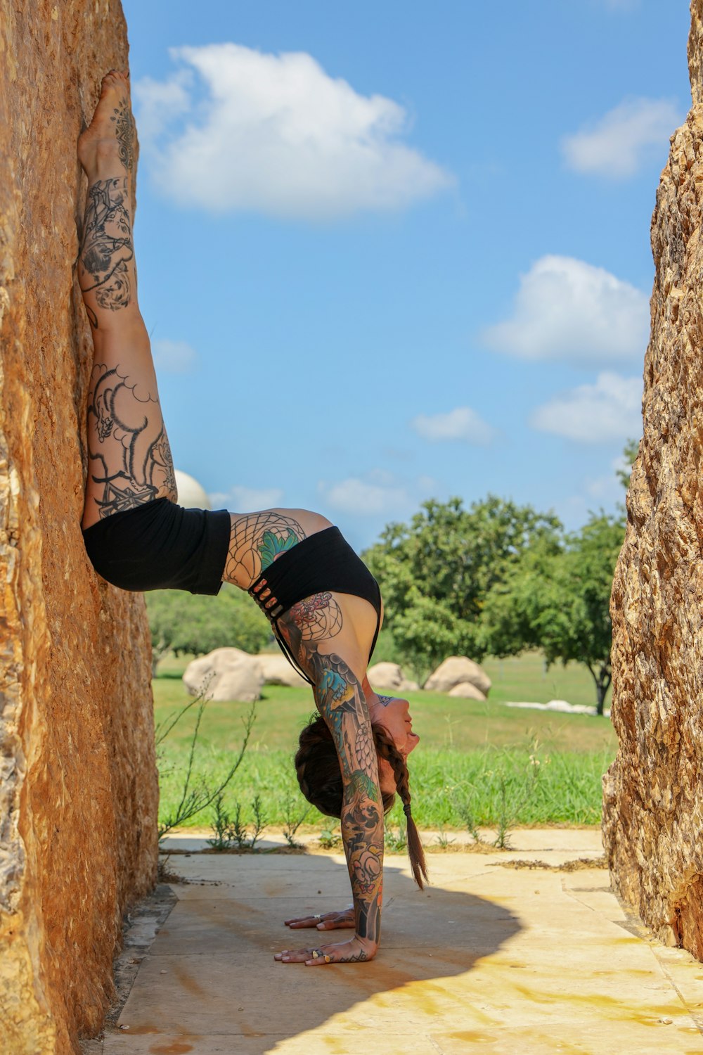 mulher no sutiã esportivo preto e shorts pretos subindo na árvore marrom durante o dia