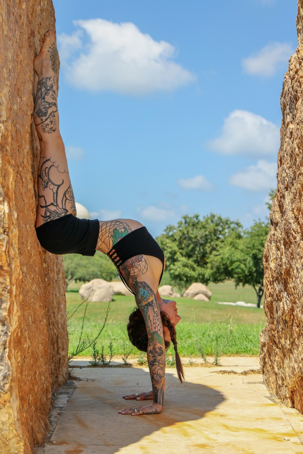 woman in black sports bra and black shorts climbing on brown tree during daytime