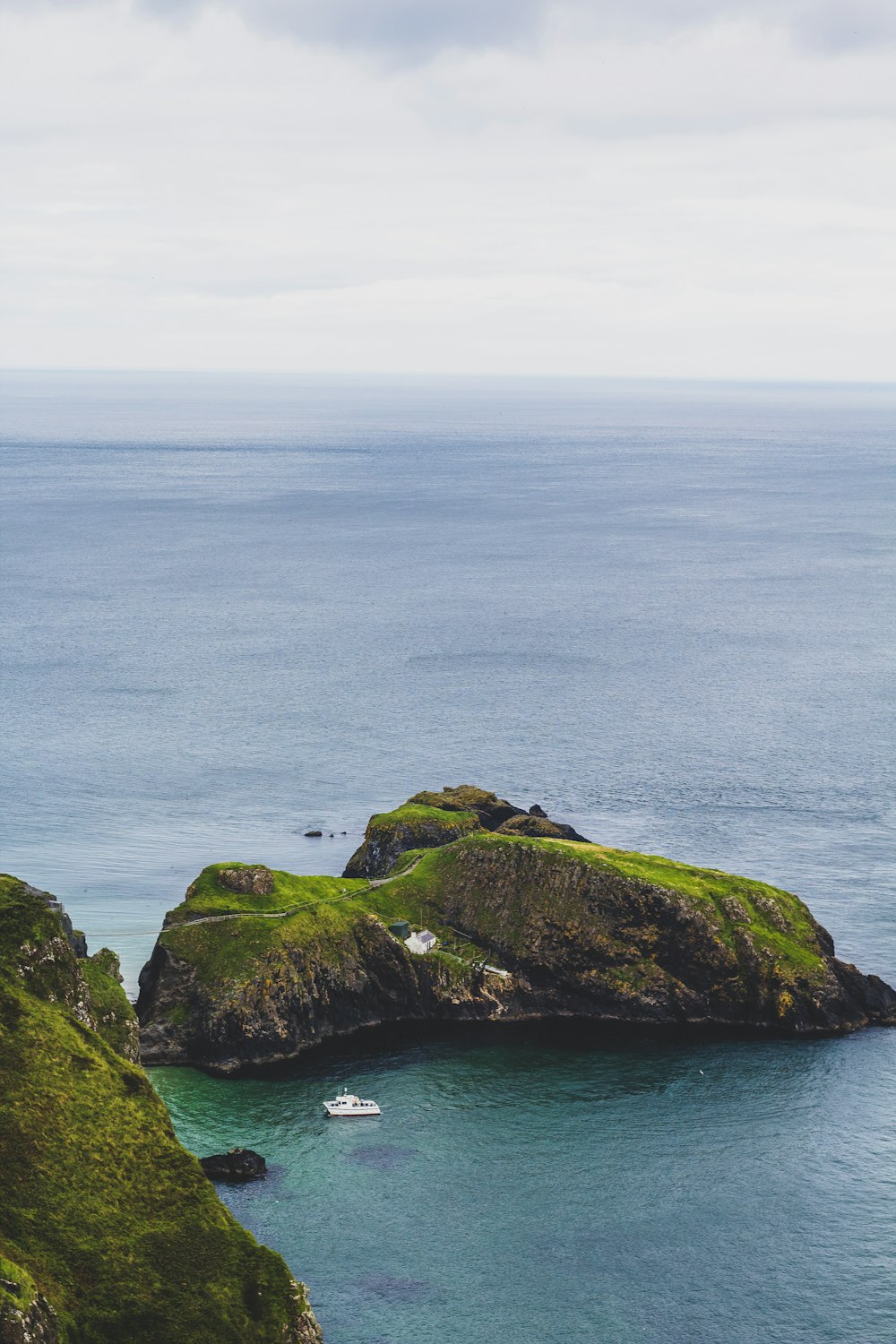 green and brown rock formation beside blue sea during daytime