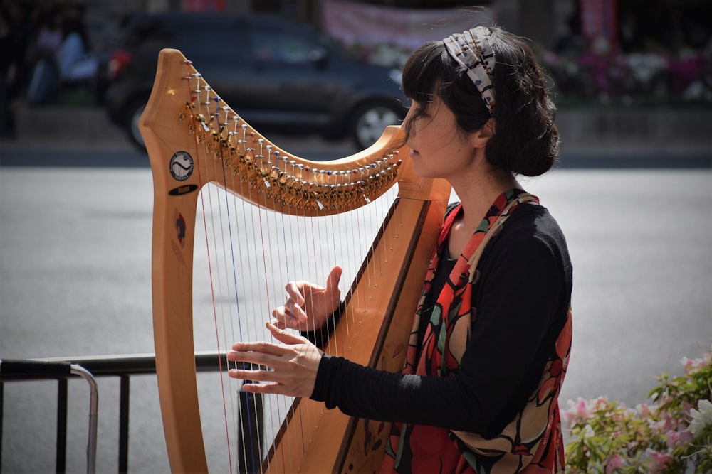 woman in black long sleeve shirt playing musical instrument