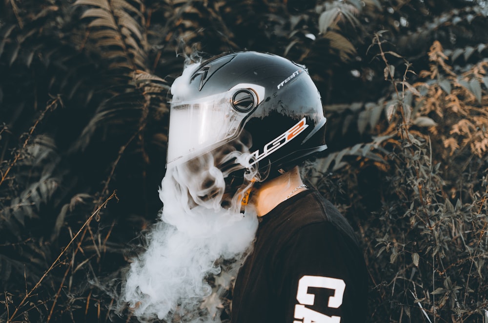 man in black and white helmet and black jacket covered with white smoke