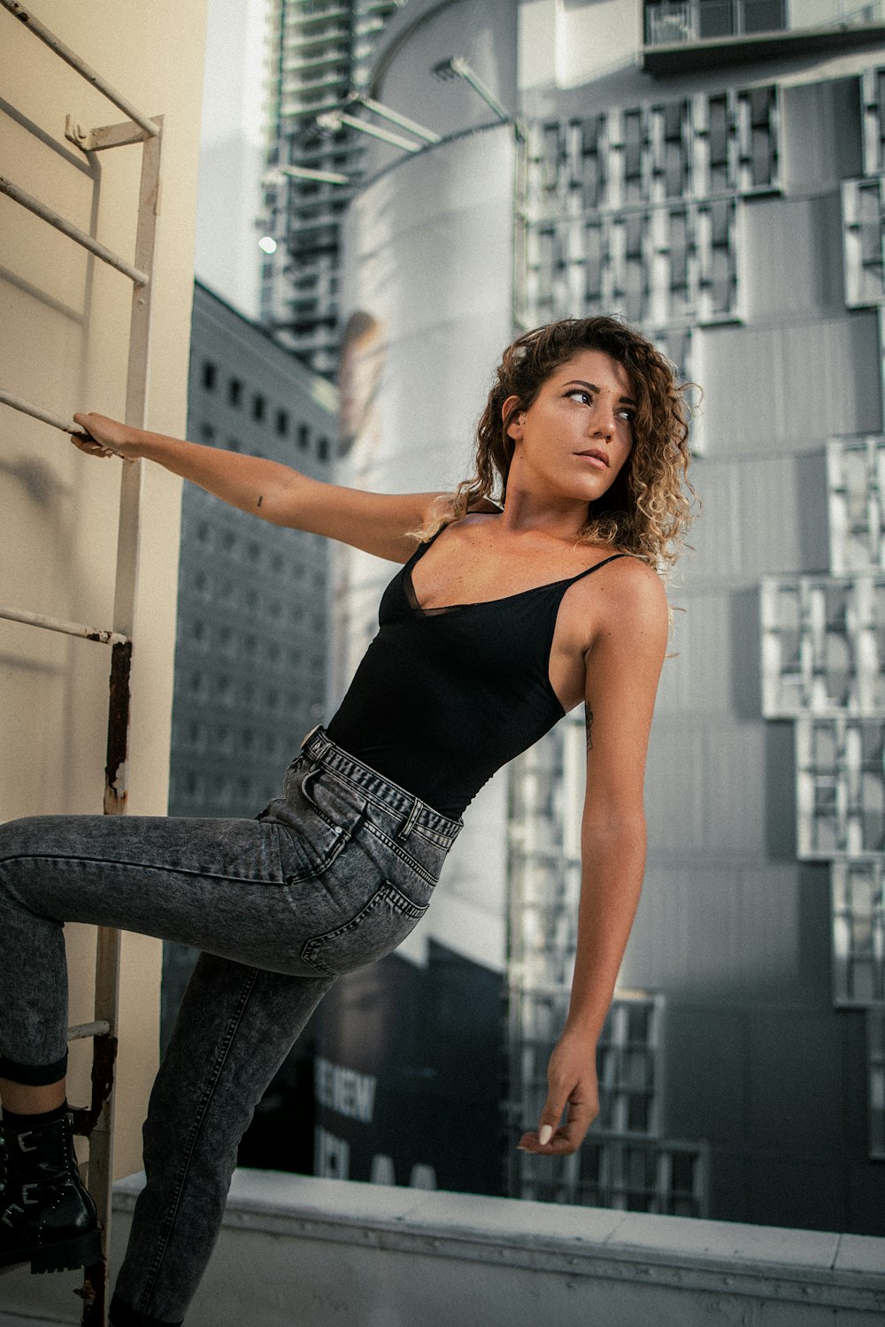 woman in black tank top and blue denim jeans