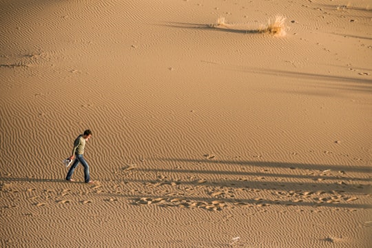 person walking on sand during daytime in Maranjab Desert Iran