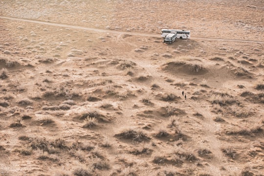 white car on brown sand in Maranjab Desert Iran