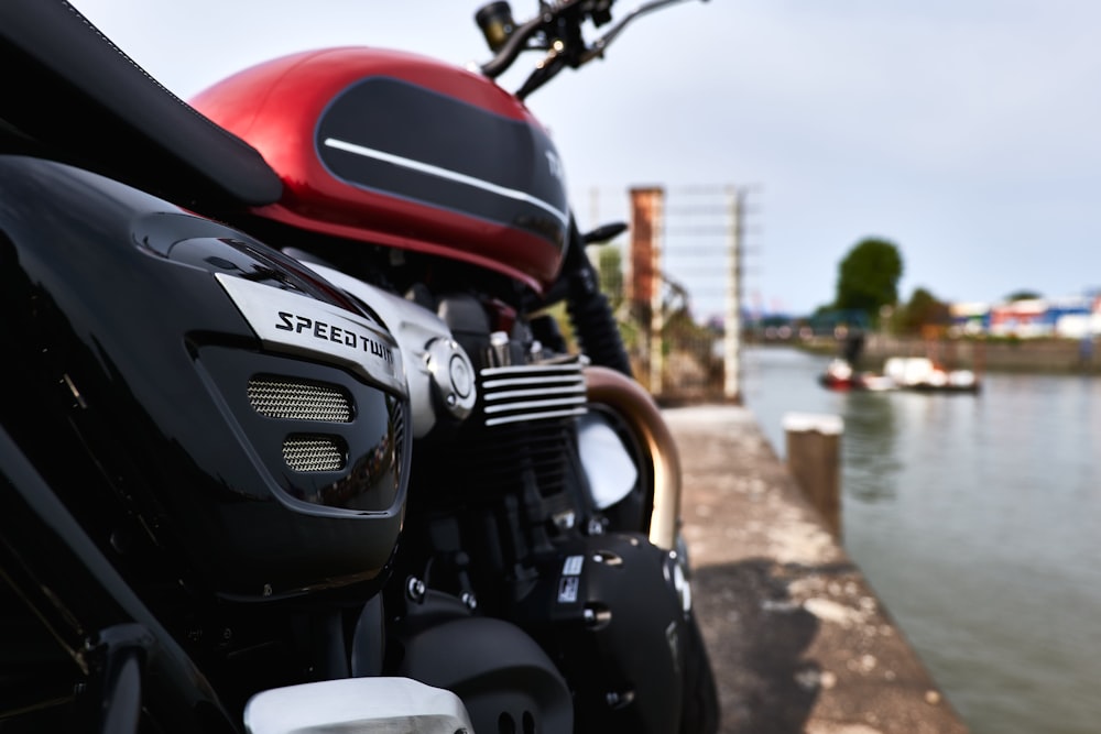 black and red motorcycle near body of water during daytime