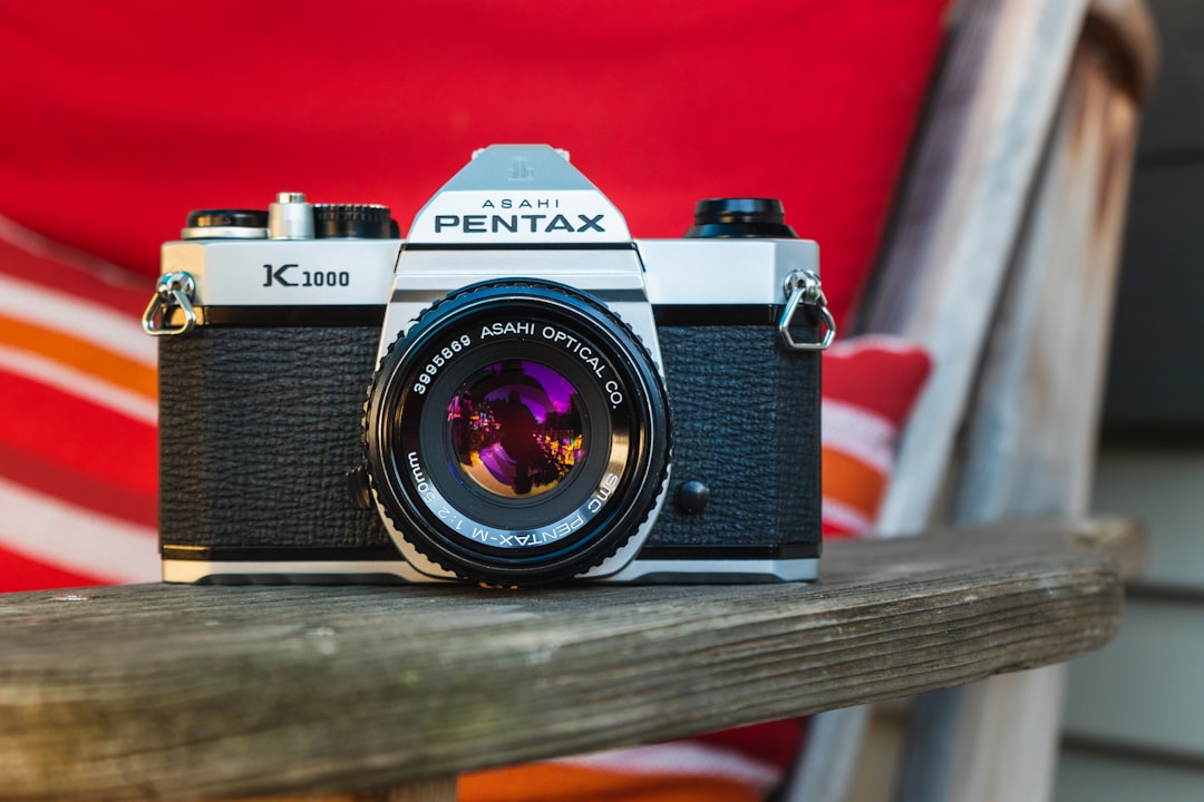 black and silver nikon dslr camera on brown wooden table