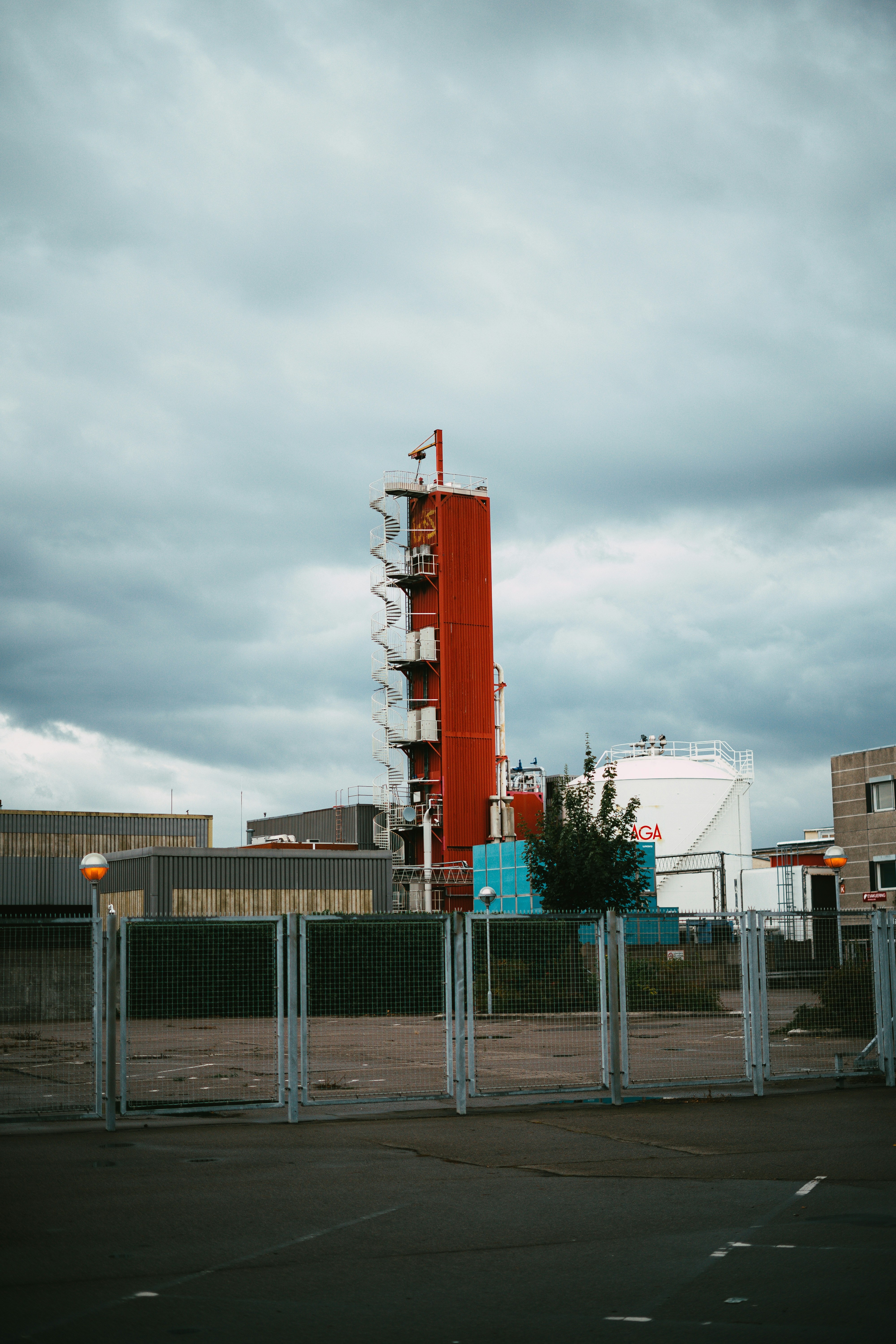 un'alta torre rossa seduta accanto a una recinzione
