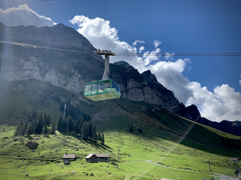 green cable car over green grass field during daytime