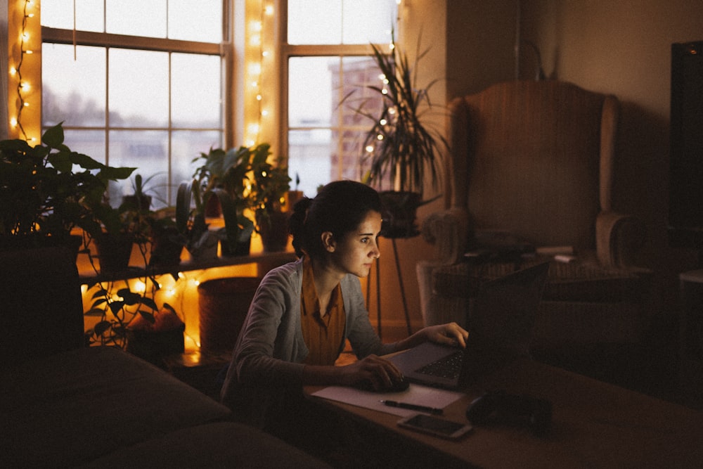 woman in gray long sleeve shirt using macbook