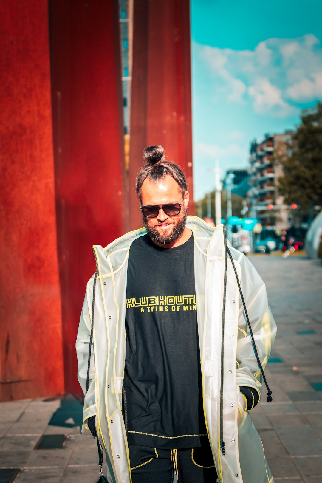 man in black crew neck shirt and white zip up jacket standing near red building during