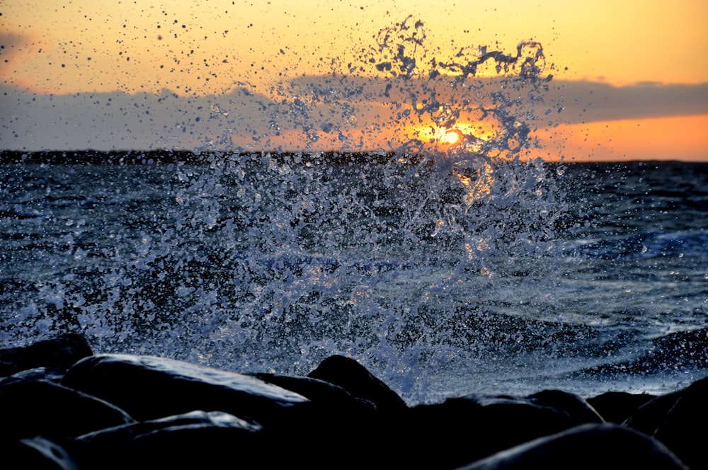 water waves hitting the shore during sunset