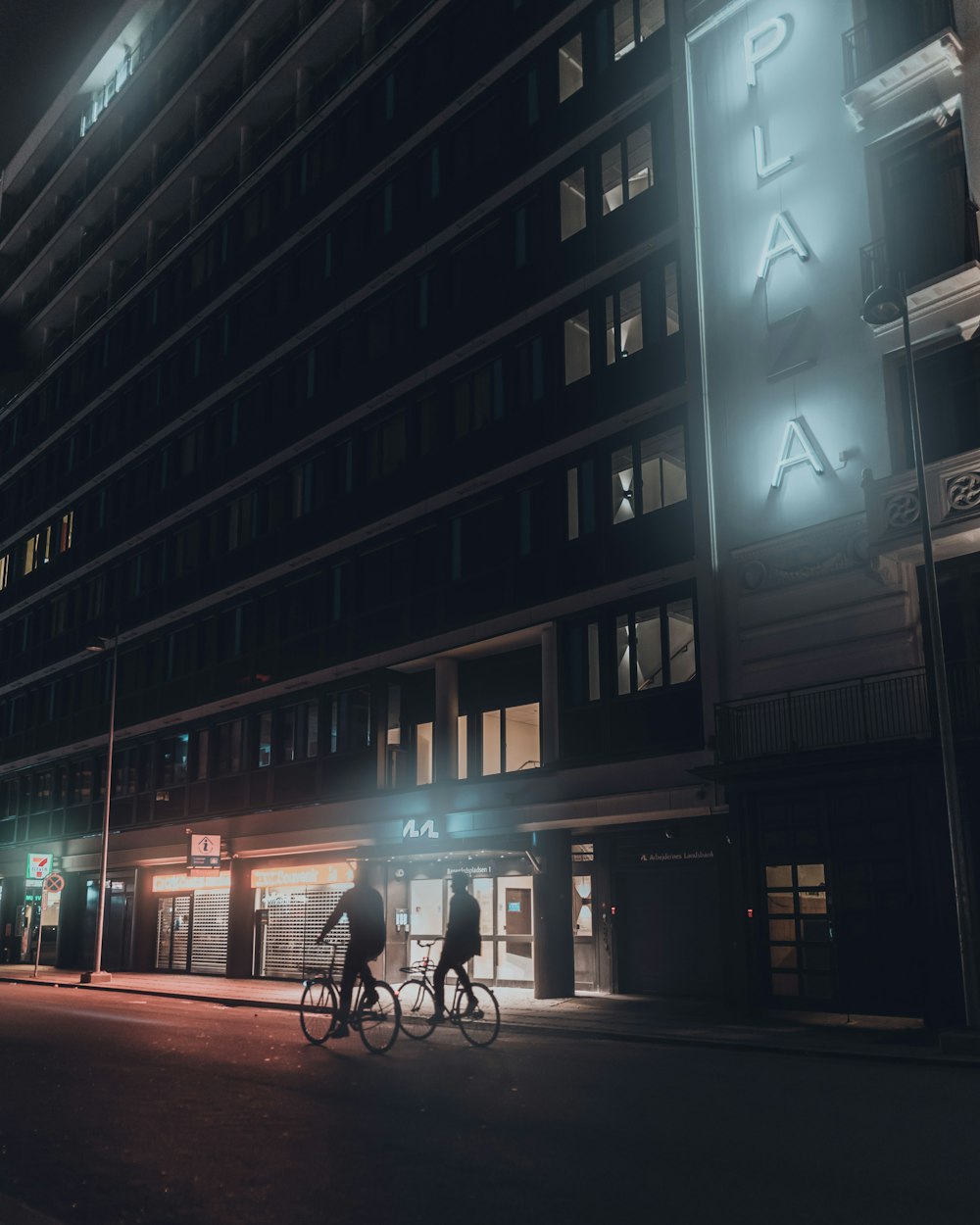 people walking on sidewalk near building during night time