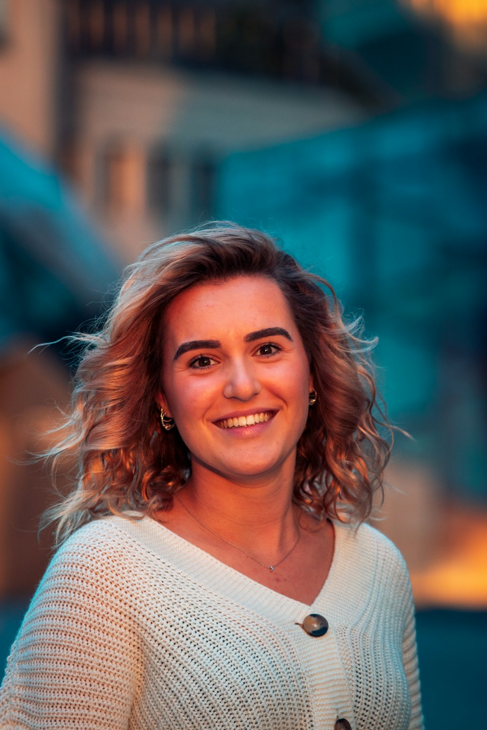 femme en pull en tricot blanc souriant