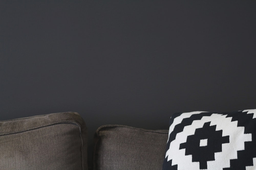 black and white checkered throw pillow on gray couch