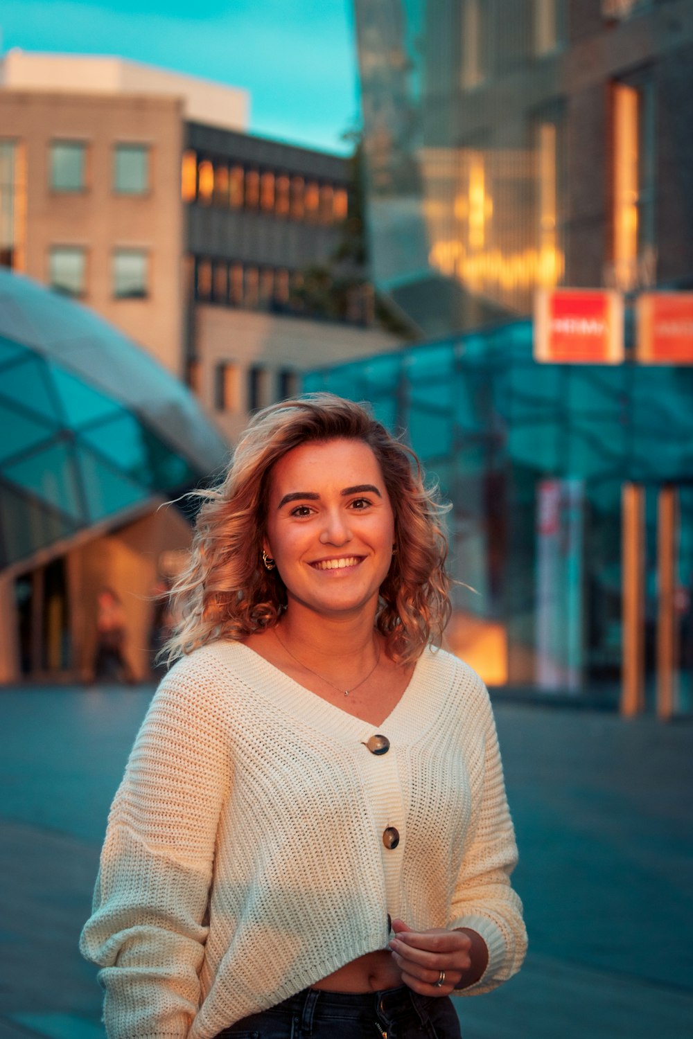 woman in white knit sweater smiling